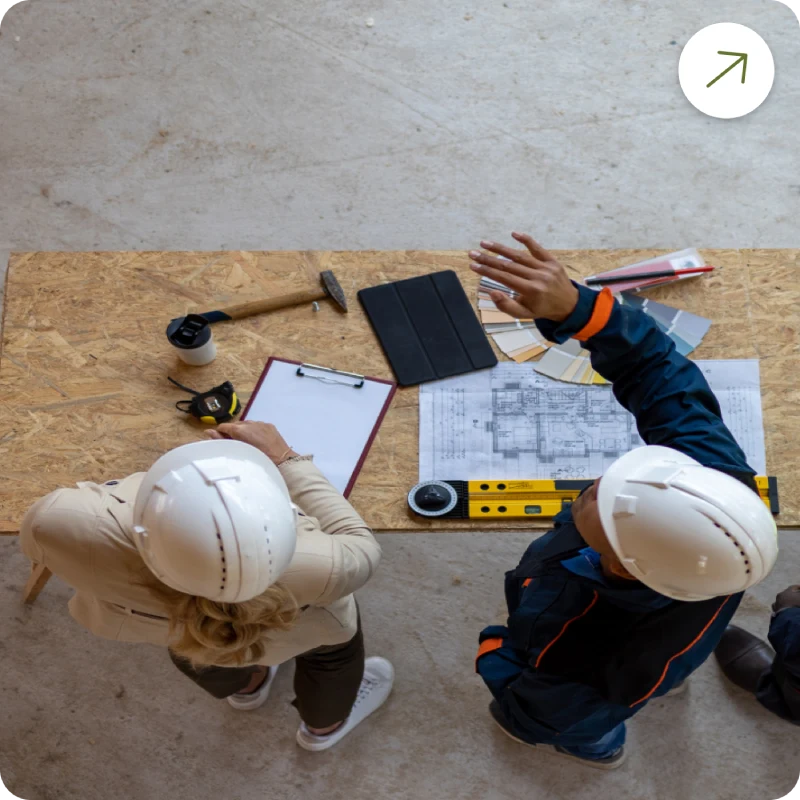 Three people discussing construction plans on a table, while conducting environmental testing.