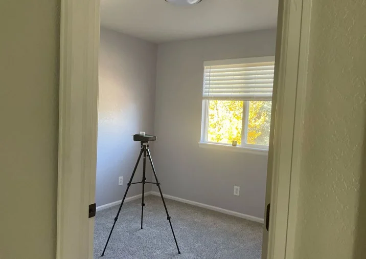 Signs of mold behind drywall might not be immediately visible, but air quality testing and inspections, such as the setup seen in this image, can help detect hidden issues.