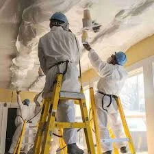 Workers in hazmat suits removing ceiling materials due to confirmed asbestos in popcorn ceiling