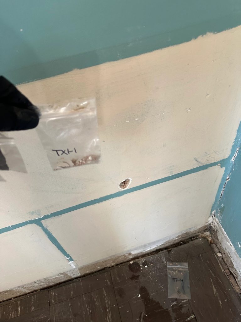 Technician collecting wall samples during home environmental testing