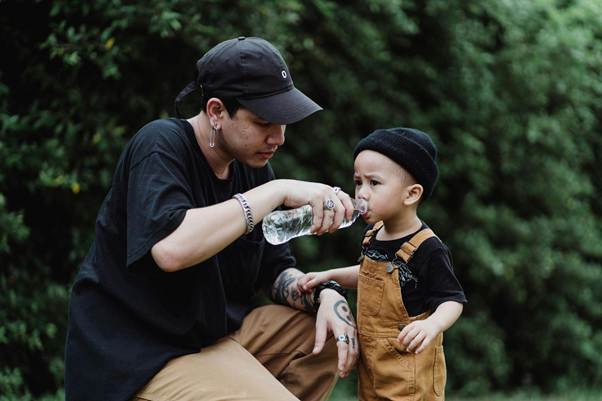 Parent giving child bottled water showing how can you tell if water is contaminated