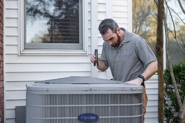 Technician inspecting air conditioning unit for black mold in air vents