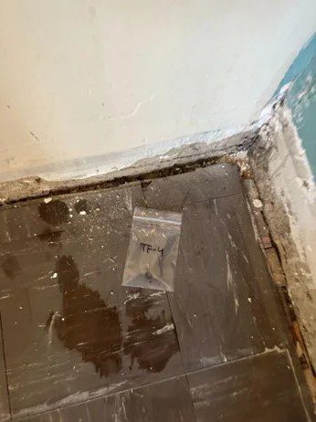 Debris and floor damage photographed for Denver asbestos remediation sampling and testing.